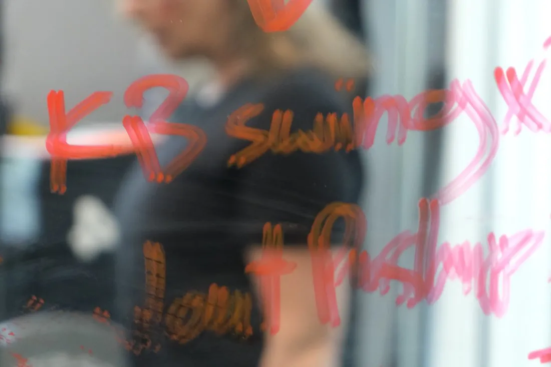 Trainer behind a glass board with the day's workout