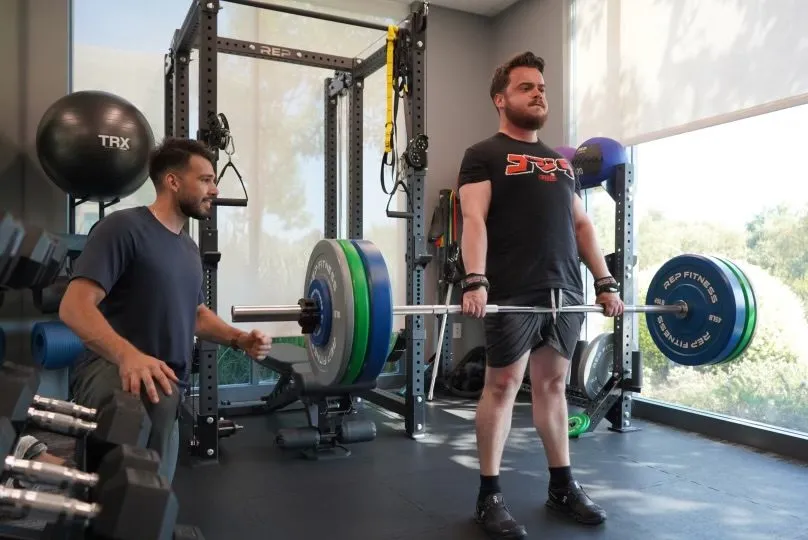 Trainer with employee training in office gym