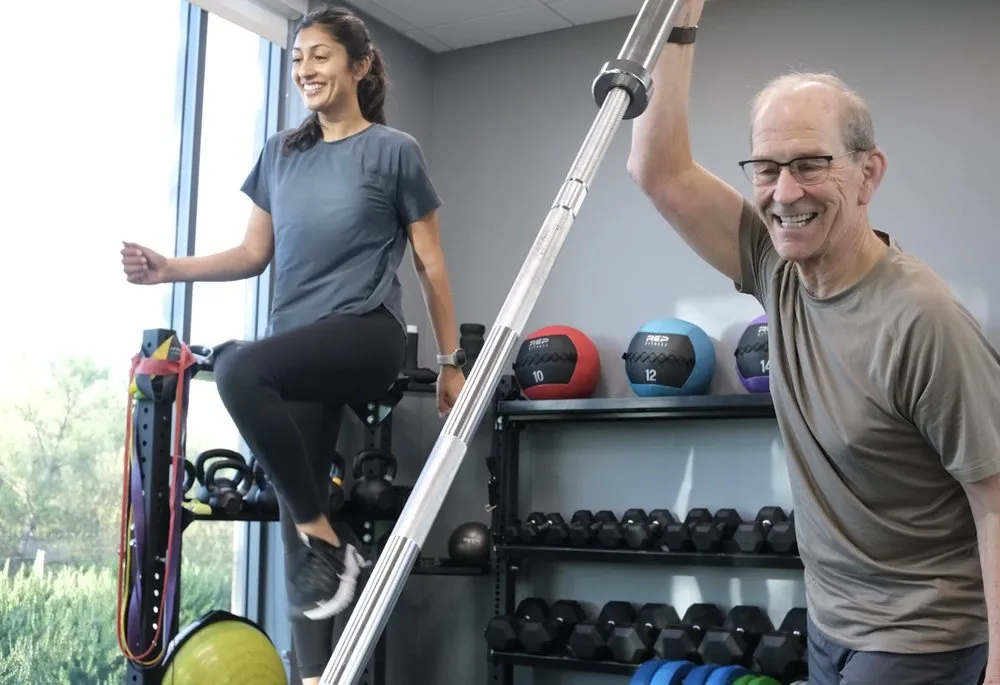 Trainer and employee working out together in the office gym
