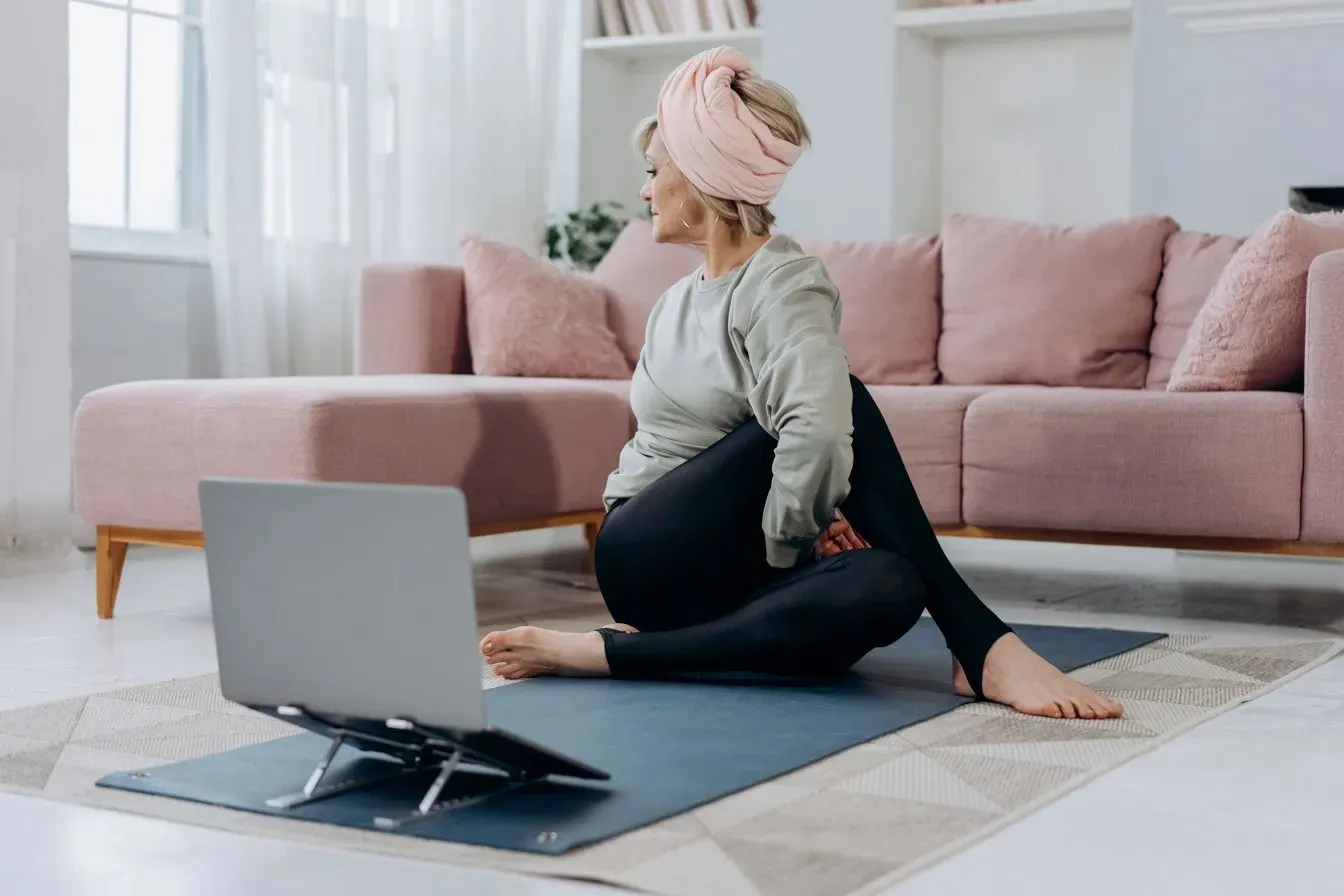 An employee following a guided mobility session at home with a laptop