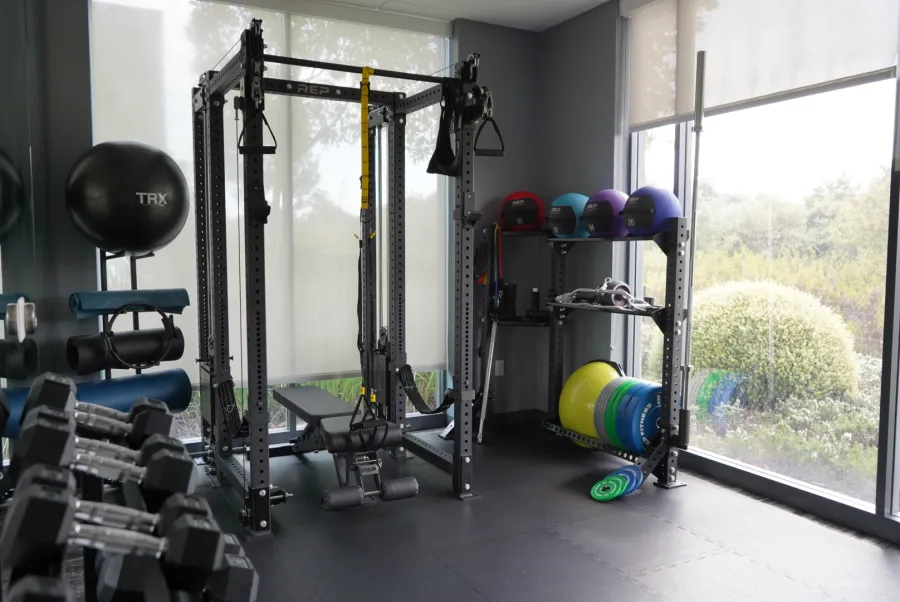Private office gym with a rack, kettlebells, and medicine balls